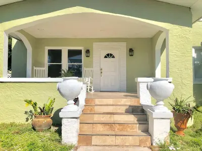 a front door of a house with two white vases at Private Studio with Free Parking in Miami