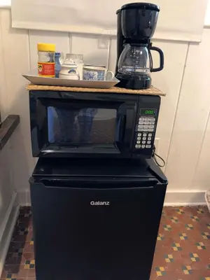 a black microwave sitting on top of a refrigerator at Private Studio with Free Parking in Miami