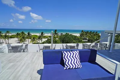 a blue couch sitting on top of a balcony with the beach at Deluxe apartments at the Congress in Miami Beach