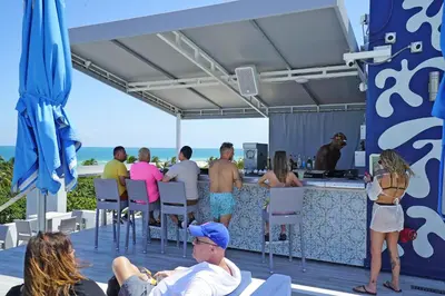 a group of people sitting around a bar at the beach at Deluxe apartments at the Congress in Miami Beach