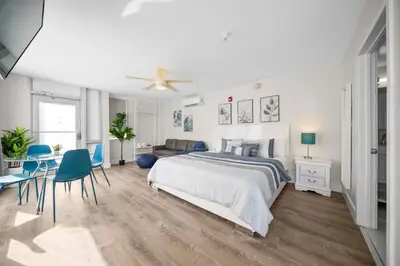 a white bedroom with a bed and a table and chairs at The Samantha by Lowkl in Miami Beach