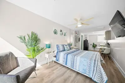 a white bedroom with a bed and a couch at The Samantha by Lowkl in Miami Beach