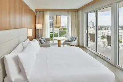 a white bed in a room with a large window at AC Hotel by Marriott Fort Lauderdale Beach in Fort Lauderdale