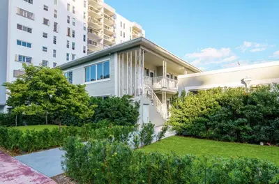 an apartment building with a lawn in front of it at Boutique Apartments Flamingo in Miami Beach