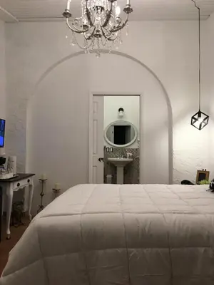 a white bedroom with a bed and a mirror at Private Loft in the Heart of Little Havana in Miami
