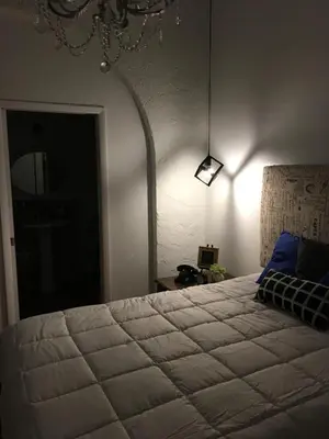 a bedroom with a large bed and a lamp at Private Loft in the Heart of Little Havana in Miami