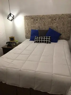 a large white bed with blue pillows in a bedroom at Private Loft in the Heart of Little Havana in Miami