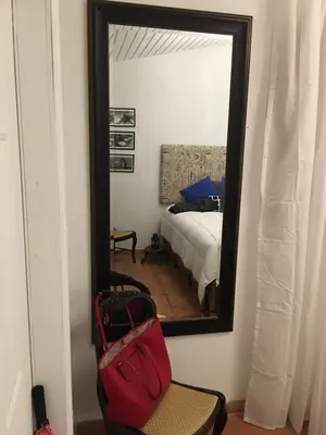 a bedroom with a bed and a mirror and a chair at Private Loft in the Heart of Little Havana in Miami