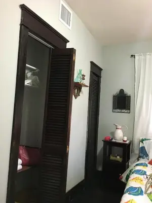 a bedroom with a wooden closet and a bed at The Jewel of Little Havana in Miami