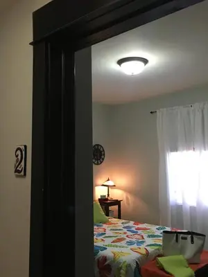 a mirror in a bedroom with a bed and a window at The Jewel of Little Havana in Miami