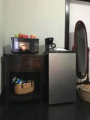 a microwave sitting on top of a table next to a mirror at The Jewel of Little Havana in Miami