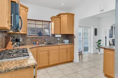 a kitchen with wooden cabinets and a stove top oven at Coral Suite close to Little Havana in Miami