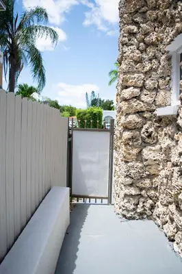 a gate to a house with a stone wall at Stay Near Miami's Cultural Heart With Wifi in Miami