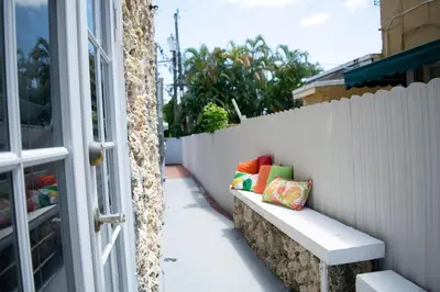 a bench with colorful pillows sitting next to a fence at Stay Near Miami's Cultural Heart With Wifi in Miami