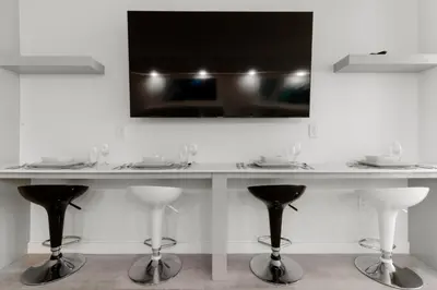 a table with chairs and a television on a wall at Elite Brickell Studio on the Bay in Miami
