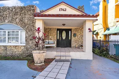 a house with a black door and a stone wall at Boho Studio in Little Havana in Miami