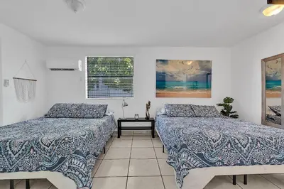 a bedroom with two beds and a table at Boho Studio in Little Havana in Miami