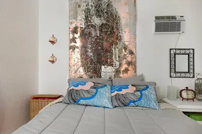 a bedroom with a bed with a painting on the wall at 1 Bedroom Apt near Coconut Grove in Miami