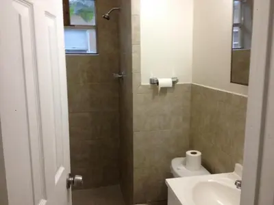 a bathroom with a shower with a toilet and a sink at 1 Bedroom Apt near Coconut Grove in Miami