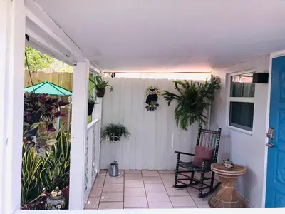 a porch with a chair and potted plants on it at Independent Studio in Little Havana in Miami