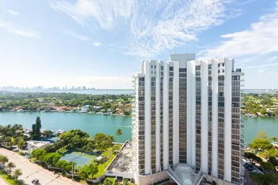 an aerial view of a tall white building next to a body of water at Girasole Suites in Miami Beach