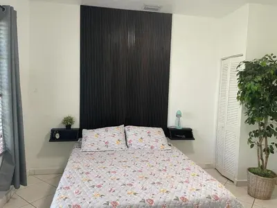 a bedroom with a bed and a black headboard at Private Suite next to Calle Ocho in Miami