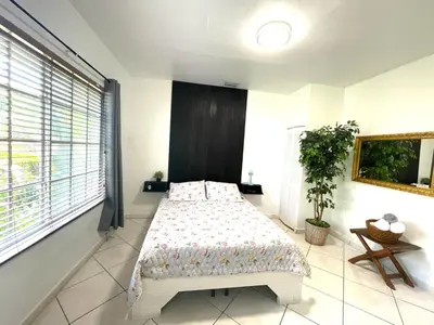 a bedroom with a bed and a large window at Private Suite next to Calle Ocho in Miami