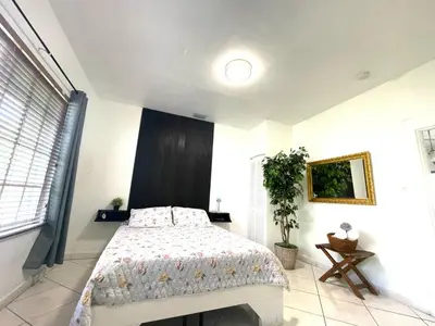 a bedroom with a bed and a large window at Private Suite next to Calle Ocho in Miami