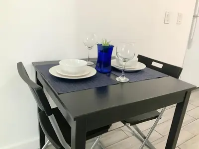a black table with two plates and wine glasses at Adorable private apartments in the Heart of Miami! in Miami