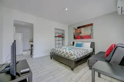 a bedroom with a bed and a tv and a couch at Adorable private apartments in the Heart of Miami! in Miami