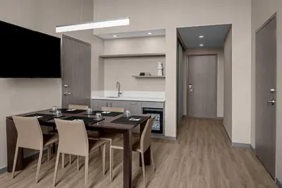 a kitchen and dining room with a table and chairs at AC Hotel by Marriott Miami Dadeland in Miami