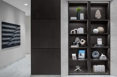 a room with a black book shelf with items on it at AC Hotel by Marriott Miami Dadeland in Miami