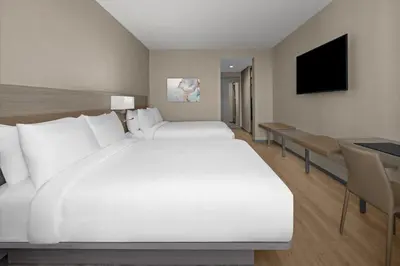 a bedroom with a large white bed and a desk at AC Hotel by Marriott Miami Dadeland in Miami