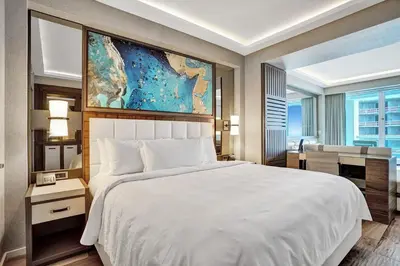 a bedroom with a large white bed and a desk at Coastal studio w hot tub gym access in Fort Lauderdale