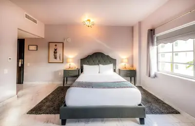 a bedroom with a large bed and two night stands at Secret Garden Miami Beach in Miami Beach