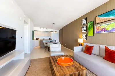 a living room with a couch and a table at Ocean view 1 bed- Steps from the beach! in Hallandale Beach