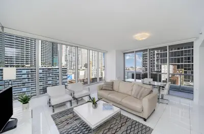 a living room with a couch and chairs and windows at Icon Brickell Miami in Miami