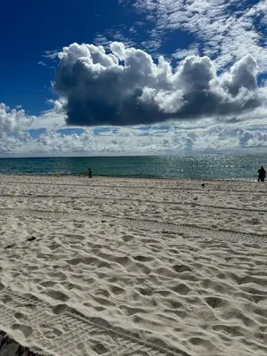 a beach with people walking on the sand and the ocean at Casablanca on the beach in Miami Beach