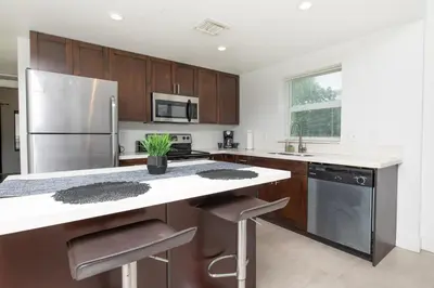 a kitchen with wooden cabinets and a stainless steel refrigerator at Spacious entire Apartment with Free Parking in Hollywood