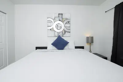 a bedroom with a white bed with a blue pillow at Spacious entire Apartment with Free Parking in Hollywood