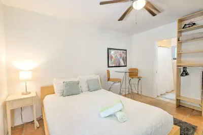 a bedroom with a white bed with a ceiling fan at Efficiency 2 on water Las Olas, beach and free kayaks in Fort Lauderdale
