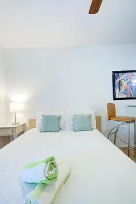 a bedroom with a white bed with towels on it at Efficiency 2 on water Las Olas, beach and free kayaks in Fort Lauderdale