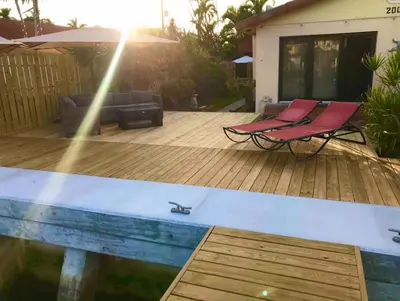 a wooden deck with two chairs and a pool at 1BR C direct on the water shared deck Free kayaks in Fort Lauderdale