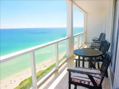 a balcony with a table and chairs and the beach at Penthouse in the sky in Miami Beach