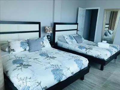 a bedroom with two beds with blue and white sheets at Penthouse in the sky in Miami Beach