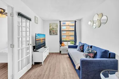 a living room with a blue couch and a tv at 1 bedroom in the BEST location in South Beach ! in Miami Beach