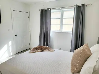 a cat laying on top of a bed in a bedroom at Stylish & Newly-Renovated Suites near Las Olas in Fort Lauderdale