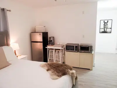 a bedroom with a bed and a microwave and a refrigerator at Stylish & Newly-Renovated Suites near Las Olas in Fort Lauderdale