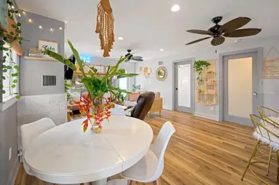 a dining room with a white table and chairs at Little “house” right on the beach in Hollywood