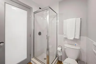 a white bathroom with a shower and a toilet at Little “house” right on the beach in Hollywood